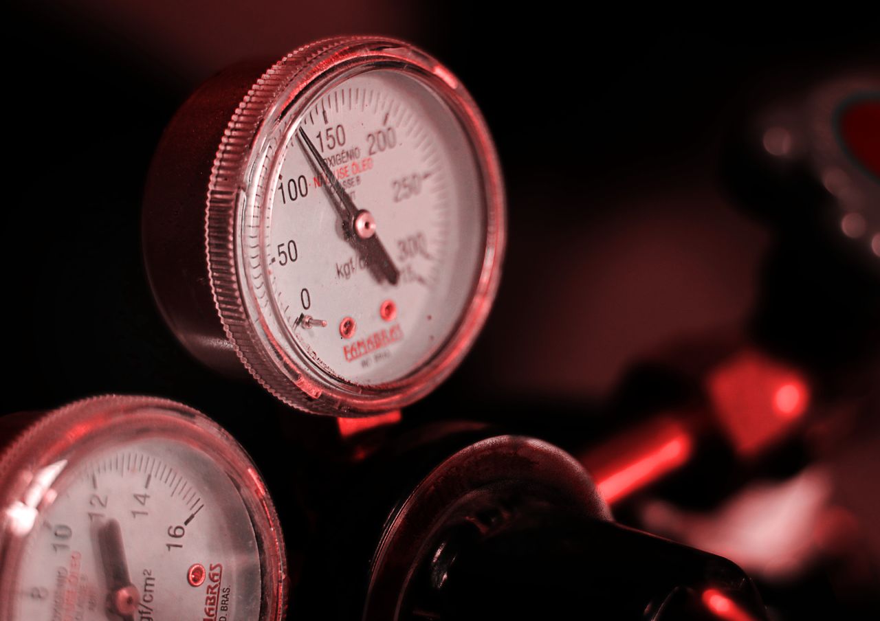 Detailed view of pressure gauges with red lighting in an industrial setting.
