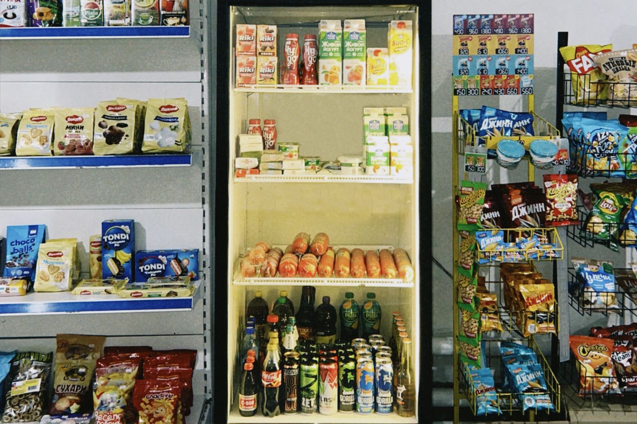 A selection of packaged snacks and drinks displayed in a Kazakhstani store showcasing diverse brands.